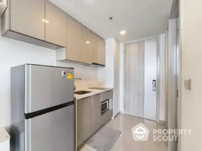 Modern kitchen with sleek cabinets and stainless steel appliances in a compact layout