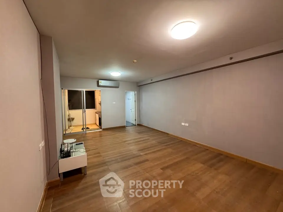 Spacious empty living room with wooden flooring and modern lighting