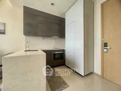 Modern kitchen with sleek cabinetry and built-in appliances in a compact layout.