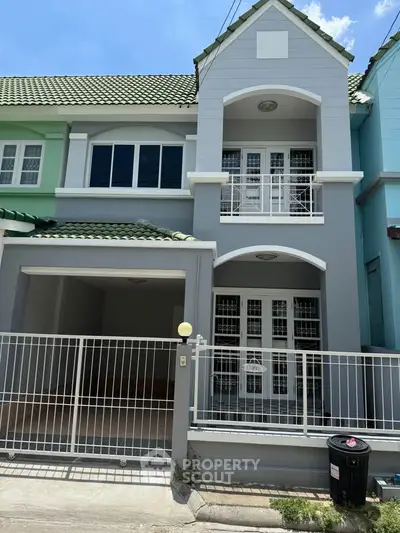 Charming two-story townhouse with modern facade and gated entrance in a vibrant neighborhood.