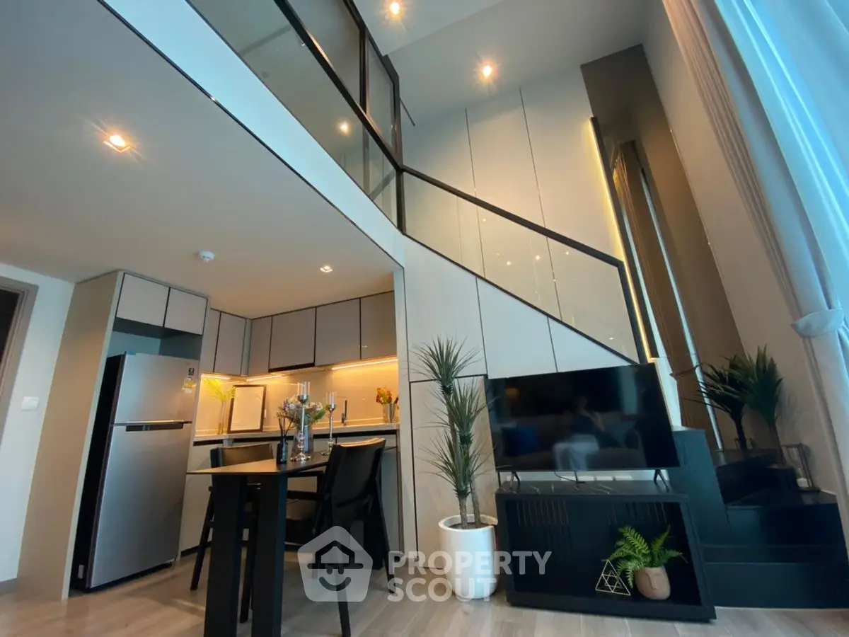 Modern duplex apartment with stylish kitchen and living area, featuring high ceilings and elegant decor.