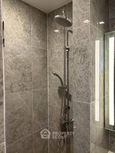 Luxurious marble-tiled bathroom with modern shower fixtures