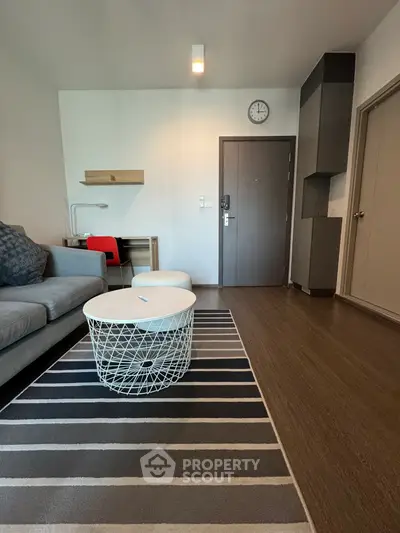 Modern living room with stylish furniture and wooden flooring, featuring a cozy sofa and chic coffee table.