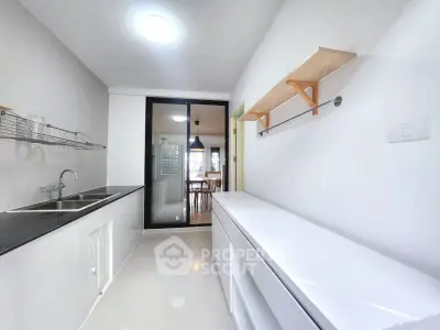 Modern kitchen with sleek design and open layout, featuring dual sinks and ample storage space.