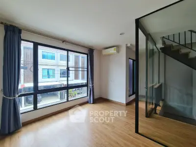 Spacious modern living room with large windows and wooden flooring