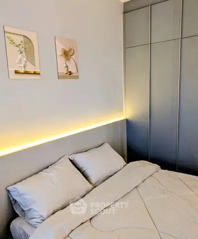 Modern bedroom with stylish decor and ambient lighting, featuring a cozy bed and elegant wall art.