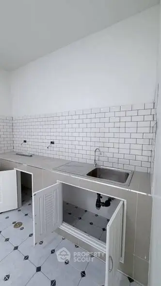 Modern kitchen with white subway tiles and open cabinets, perfect for customization.