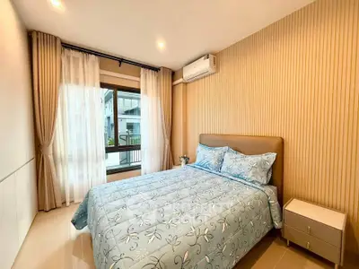 Modern bedroom with stylish decor and large window offering natural light.