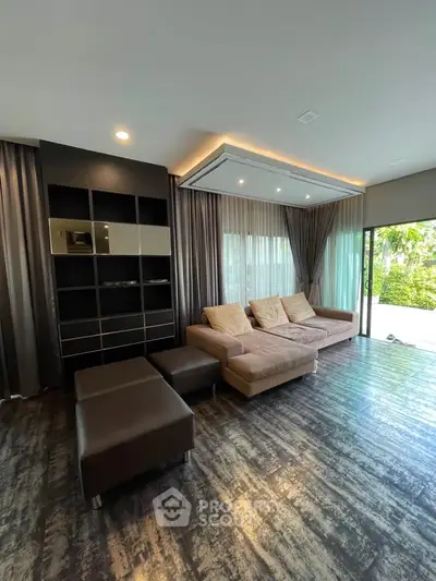 Luxurious living room with modern decor and large windows overlooking greenery.