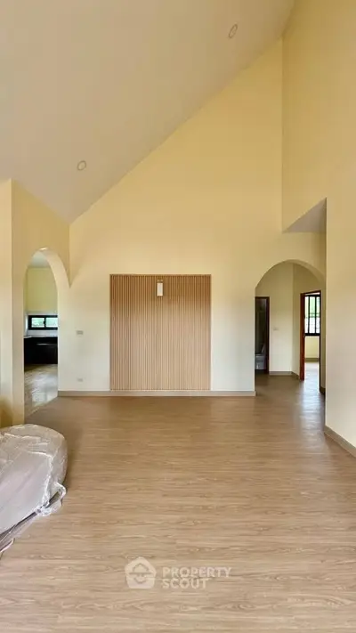 Spacious living room with high ceilings and wooden flooring, perfect for modern living.