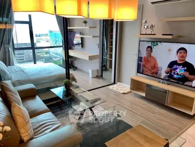 Modern living room with open layout, stylish furniture, and large windows offering city views.