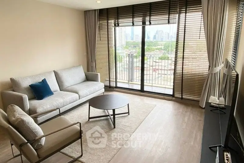 Modern living room with city view, large windows, and stylish furniture.
