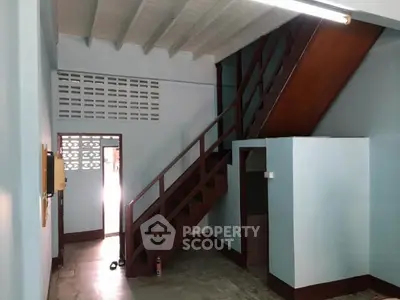 Charming interior with wooden staircase and high ceiling, perfect for renovation enthusiasts.