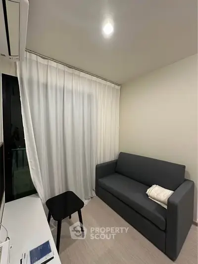 Cozy living room with modern gray sofa and sleek black side table, perfect for relaxation.