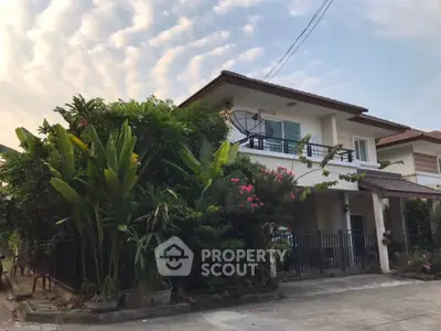 Charming two-story house with lush garden and spacious driveway in serene neighborhood.