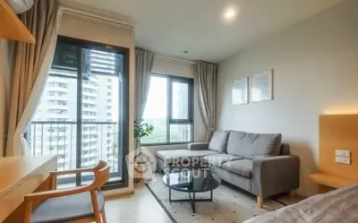 Modern living room with large windows and city view, featuring a cozy gray sofa and stylish decor.