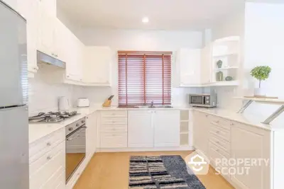 Bright and modern kitchen with white cabinetry and gas stove