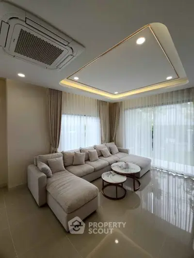Luxurious living room with elegant ceiling design and plush sectional sofa.