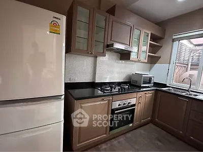 Modern kitchen with gas stove, oven, and spacious fridge in a stylish home.