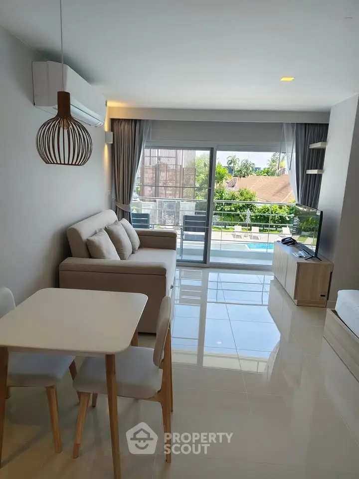 Modern living room with pool view, featuring sleek furniture and natural light.