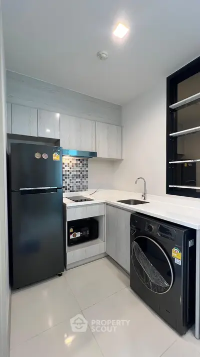 Modern kitchen with sleek appliances and stylish cabinetry in a compact layout.