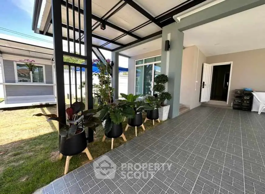 Modern home entrance with stylish potted plants and tiled pathway