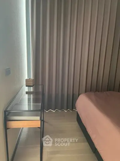 Modern bedroom with sleek glass desk and elegant curtains