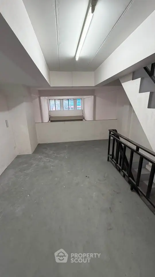 Spacious basement area with concrete flooring and staircase, ideal for storage or renovation.