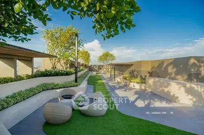 Luxurious rooftop garden with modern seating and lush greenery under a clear blue sky.