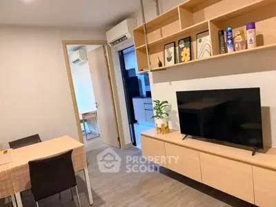 Modern living room with sleek furniture and open layout, featuring a TV and stylish shelving.