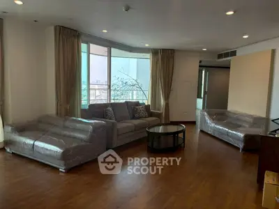 Spacious living room with modern furniture and city view, perfect for urban living.