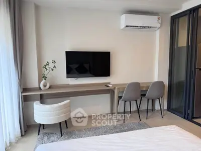 Modern bedroom with stylish furniture, wall-mounted TV, and air conditioning, perfect for comfort and relaxation.