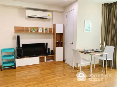 Modern living room with stylish decor and dining area, featuring wooden flooring and air conditioning.