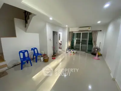 Spacious living room with modern lighting and sliding glass doors leading to a balcony.
