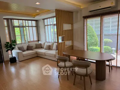 Spacious living room with modern furniture and large windows overlooking garden