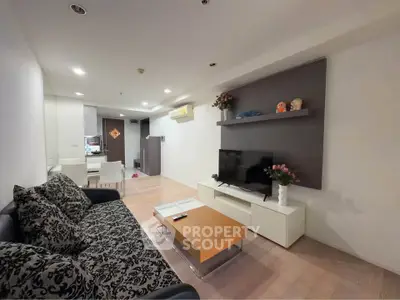 Modern living room with stylish decor and open layout, featuring a cozy sofa and entertainment center.