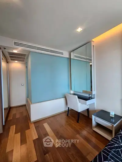 Modern bedroom with wooden flooring and stylish furniture