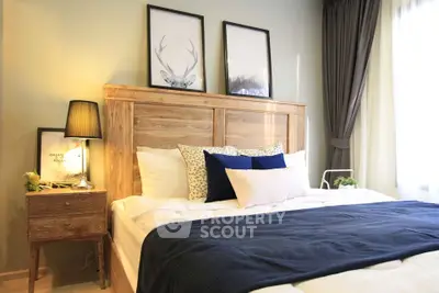 Cozy bedroom with stylish decor and natural light, featuring a wooden headboard and elegant framed art.