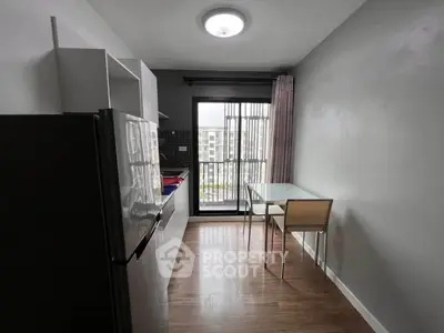 Modern kitchen with sleek appliances and dining area, featuring a bright window view.
