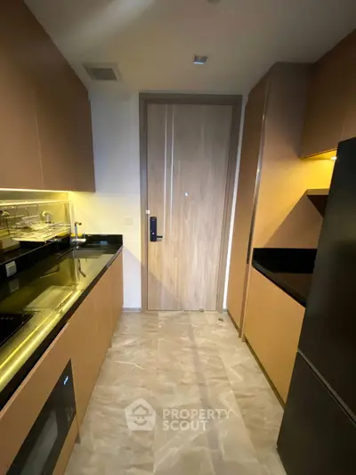 Modern kitchen with sleek cabinets and built-in appliances in a compact layout.