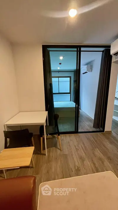 Modern studio apartment with open layout and stylish furnishings, featuring a cozy bedroom and sleek wooden flooring.