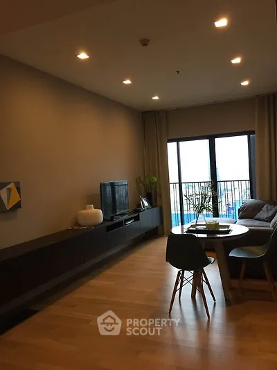 Modern living room with stylish furniture and large windows offering a city view.