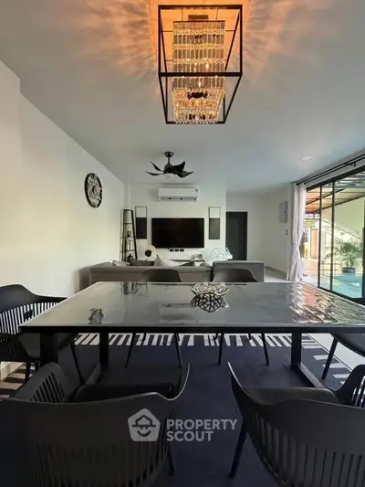 Modern living room with elegant chandelier and stylish furniture, perfect for contemporary lifestyle.