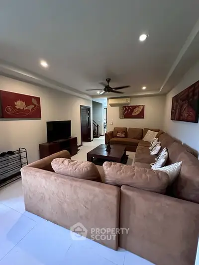 Spacious living room with cozy sectional sofa and modern decor, perfect for relaxation and entertainment.