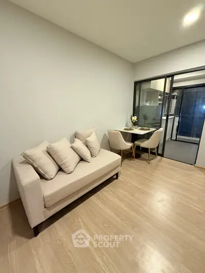 Modern living room with cozy sofa and dining area, featuring sleek wooden flooring and elegant decor.