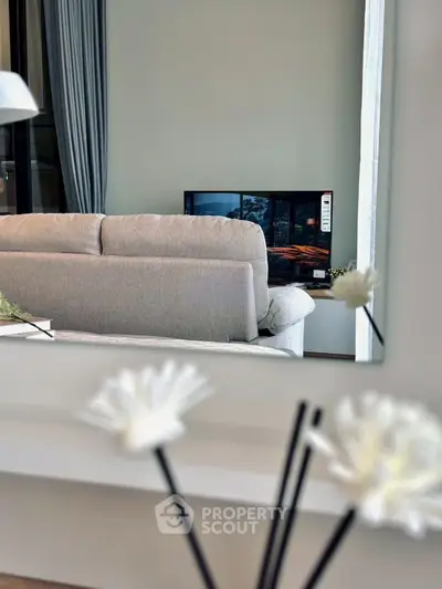 Modern living room with cozy sofa and flat-screen TV, perfect for relaxation and entertainment.