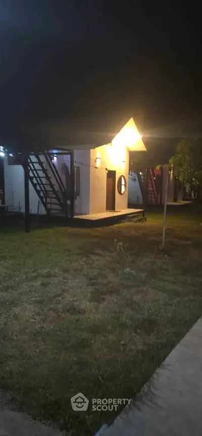 Charming night view of modern cabin with unique architecture and outdoor lighting.