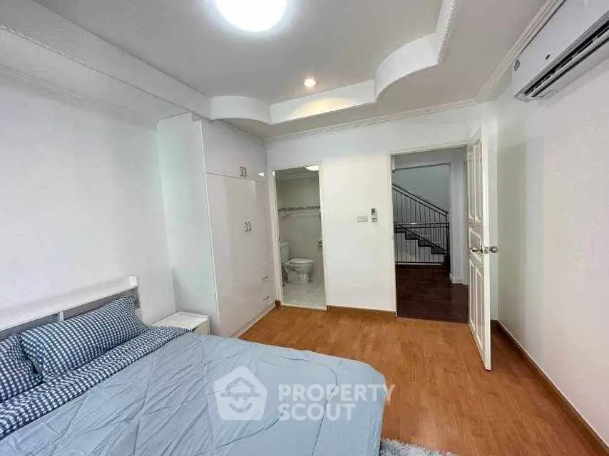 Spacious bedroom with modern design and ensuite bathroom in a stylish home.