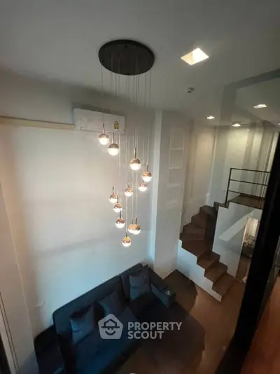Modern duplex living room with stylish lighting and cozy seating area.