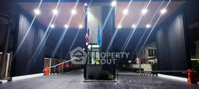Modern gated entrance with sleek design and bright lighting, perfect for secure residential community.